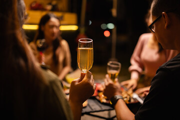 Happy Friends Celebrating Together at Night, Young Asian Group of Friends Having Fun and Toasting Drinks Outdoors, Enjoying a Celebration Concept.