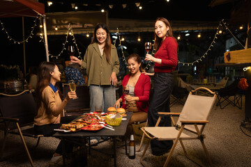 Happy Group of Woman Friends Celebrating Together at Night, Сlinking glasses of dinner at a social gathering.