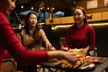 Happy Group of Woman Friends Celebrating Together at Night, Сlinking glasses of dinner at a social gathering.