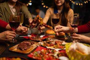 Happy Group of Woman Friends Celebrating Together at Night, Сlinking glasses of dinner at a social gathering.