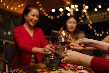 Happy Group of Woman Friends Celebrating Together at Night, Сlinking glasses of dinner at a social gathering.