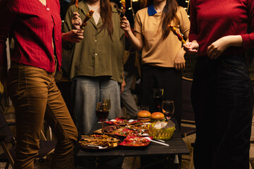 Happy Group of Woman Friends Celebrating Together at Night, Сlinking glasses of dinner at a social gathering.