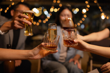 Happy Friends Celebrating Together at Night, Young Asian Group of Friends Having Fun and Toasting Drinks Outdoors At Night, Enjoying a Celebration Concept.
