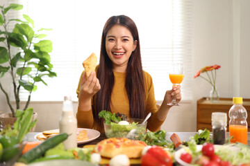 Happy young woman enjoying delicious homemade pizza at home.