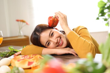Happy young woman enjoying delicious homemade pizza at home.