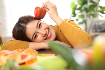 Happy young woman enjoying delicious homemade pizza at home.
