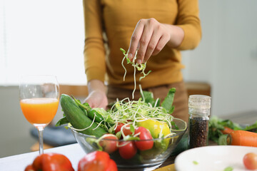 Happy young woman preparing healthy food in the kitchen.