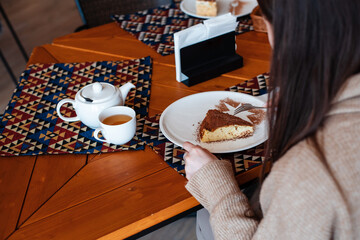 Woman Enjoying Cake and Tea at Cafe