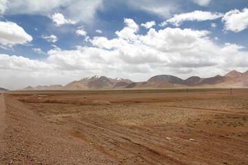 Vast arid land with distant mountains under a cloudy sky