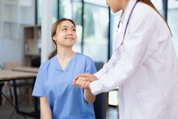 Professional encouragement, Doctor reassuring and supporting her colleague or junior staff member,...