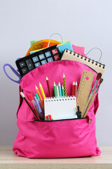Pink backpack full of school supplies preparing for education