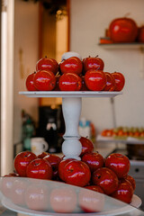 Candied red apples on white stand. Red candied apples displayed on a white stand at a festive market, symbolizing traditional sweet dessert and celebration treats