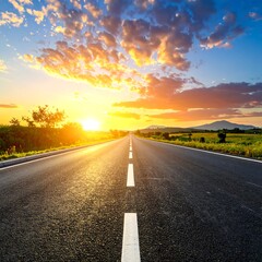Asphalt road stretches to sunset