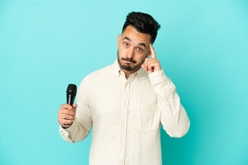 Young caucasian singer man isolated on blue background thinking an idea
