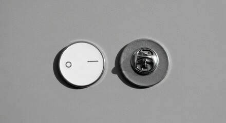 Two minimalist, round, white pins with a thin black line; gray background