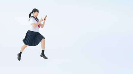 スマホを見ながらジャンプするセーラー服を着た女子学生の切り抜き全身写真（切り抜き背景透過PNGも販売しております。&darr;作成者リンクから「PNG」で検索してください）