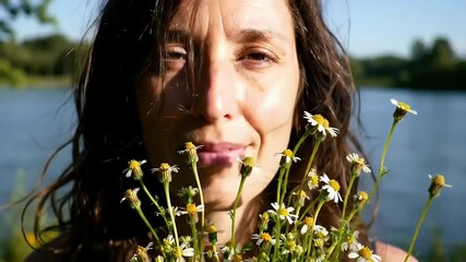 Woman's Serene Close Up Embracing Daisies by the Lake During Mental Health Awareness Day With Gentle Sunlight And Calm Waters For Campaign and Advertisement Backdrop 195 characters