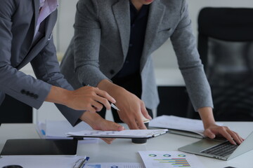 Hand of business team holding a pen, discussing marketing analytics at the office.