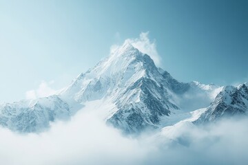 Obraz premium Majestic snow-capped mountain peaks rise above clouds in bright blue sky during midday