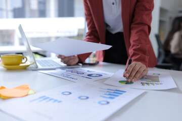 Hand of businesswoman holding a pen, discussing marketing analytics at the office.