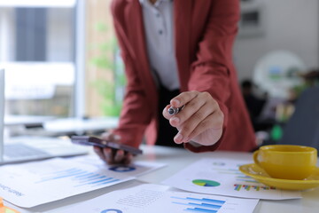 Hand of businesswoman holding a pen, discussing marketing analytics at the office.