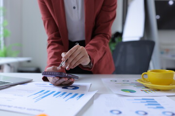 Hand of businesswoman holding a pen, discussing marketing analytics at the office.