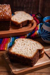 Salvadoran yolk bread, accompanied by a cup of hot chocolate.