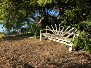 two wooden benches along a rough dirt hiking path in a natural park - hiking through the trees in a dry mountainous forest - Escondido, California, USA