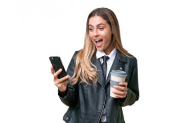 Business pretty Uruguayan woman wearing a biker jacket over isolated background holding coffee to take away and a mobile