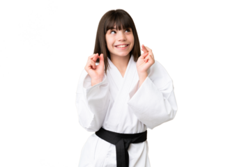 Little Caucasian girl doing karate over isolated background with fingers crossing