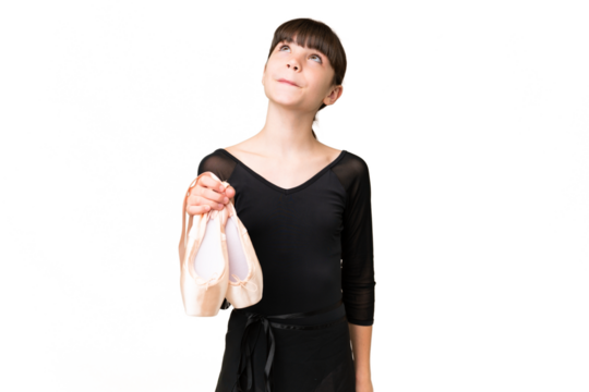 Little caucasian girl practicing ballet over isolated background and looking up