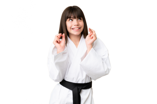 Little Caucasian girl doing karate over isolated background with fingers crossing - Powered by Adobe