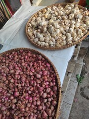 Two Wicker Baskets Filled With Fresh Shallots and Garlic On Display