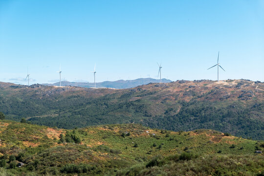 Parque e&oacute;lico das Terras Altas de Fafe em Cabeceiras de Basto, com algumas turbinas e&oacute;licas no alto da montanha sob o c&eacute;u azul em Portugal