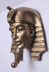 Golden pharaoh mask sculpture with turquoise accents, featuring alien-inspired eyes. A mysterious blend of ancient Egyptian symbolism and cosmic allure. Unique contemporary sculpture.