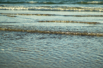 Small ocean waves on sandy beach close-up in Iceland