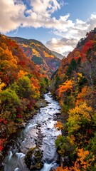 A vibrant river flows through an autumnal valley, surrounded by steep hillsides ablaze with red, orange, and yellow foliage
