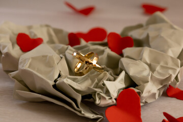Wedding Rings on Paper with Soft Light &ndash; Anniversary Concept. Elegant close-up of gold wedding rings on paper background using diffused light and neutral colors to express fragility, trust