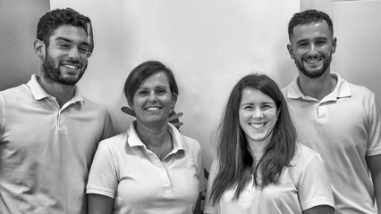 Group of four young Caucasian physiotherapists smiling in their professional clinic