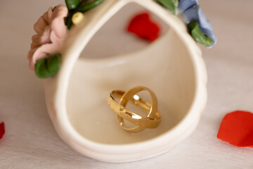 Wedding Rings Still Life on Ceramic Faience &ndash; Anniversary Concept. Soft and elegant still life of gold wedding rings on ceramic faience background representing harmony, balance, and timeless marriage 
