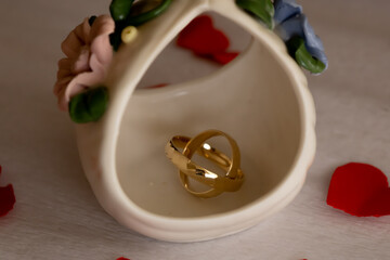 Gold Wedding Rings on Decorative Faience Background &ndash; Wedding Anniversary. Gold wedding rings photographed on a decorative faience surface with warm tones, symbolizing tradition, craftsmanship