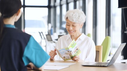 介護施設の説明を受けるアジア人高齢者