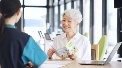 介護施設の説明を受けるアジア人高齢者