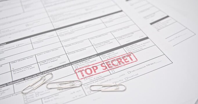 Close-up of classified document stamped TOP SECRET in red. Concept of restricted files, government secrecy, privacy, and confidential data protection.