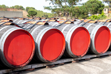 Old oak barrels for aging of natural sweet red grand cru wine Banyuls outdoor in sunlights, ...