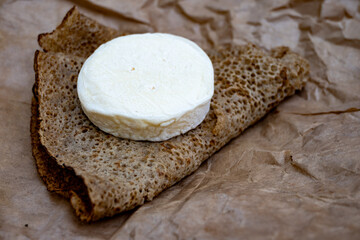 Rocamadour soft goat AOC cheese with soft rind and French buckwheat pancake eated on picnic outdoor, Lot, France