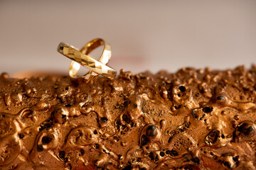 Bronze Wedding Anniversary. Wedding Rings on Bronze Textured Background &ndash; Bronze Anniversary