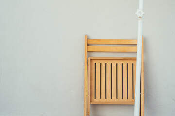 wooden chair in front of white wall