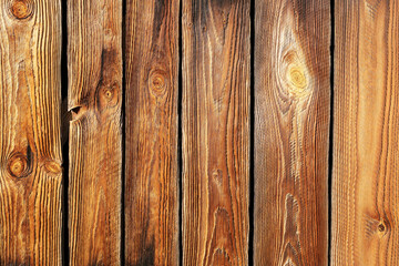 Naklejka premium Wooden planks background texture. Brown wood surface closeup. Rustic timber detail. Natural construction material. Old wooden boards for design. Outdoor architecture element.