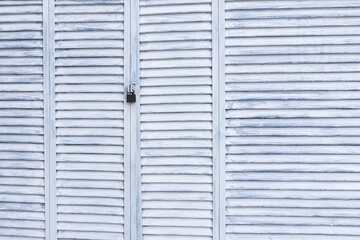 Abstract background of light painted planks of shutters, gates locked. Aged wood surface texture. A copy of the space.
